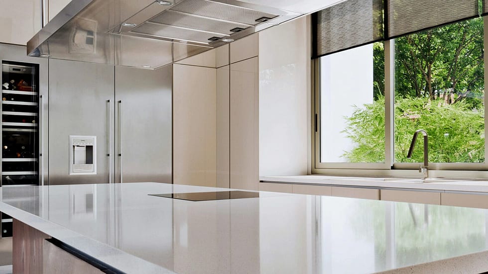 The white kitchen with Caesarstone snow quartz worktops has a sleek design with plenty of storage in the cabinets.